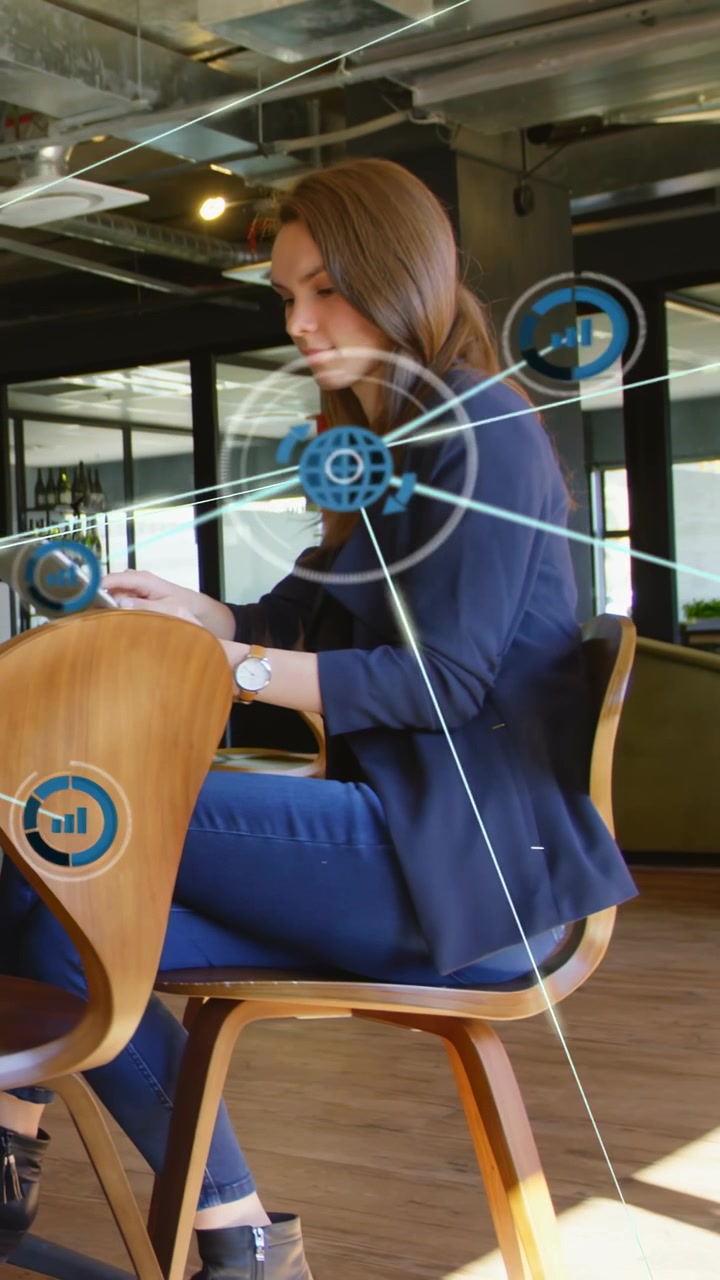 Vertical video: Woman tapping laptop in IT office working and visualizing blue network HUD overlays