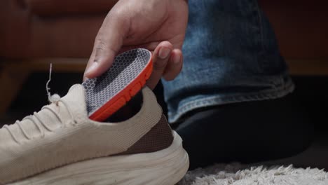 man putting on insoles in his shoes