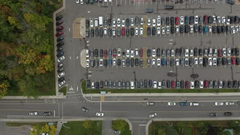 Vertikale-Drohnenaufnahme-über-Dem-Kopf-Eines-Belebten-Parkplatzes-Mit-Darin-Fahrenden-Autos