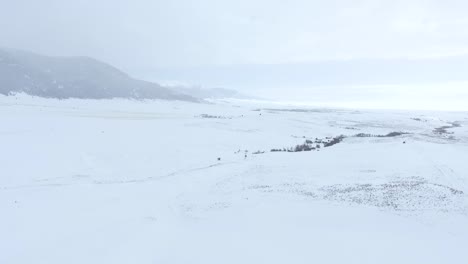 aerial - snow covered valley with mountains in the distance