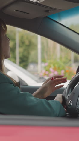 businesswoman turns steering wheel moving slowly in traffic jam in city center. young female driver in personal vehicle hurries up to work closeup