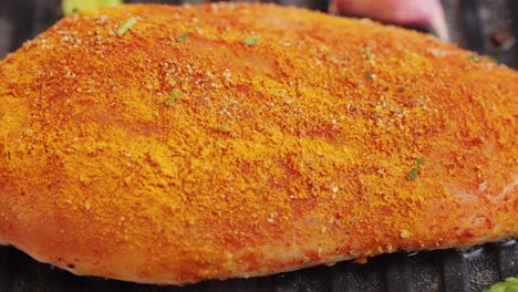 cooking raw chicken meat in yellow turmeric spice with garlic and greens on grill close-up. preparing raw food for cooking. grilled chicken, duck, turkey kebab with vegetables.