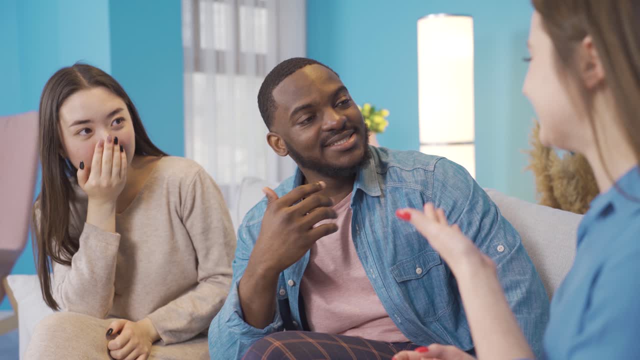 adolescentes asiáticos y africanos escuchando a sus amigos desconcertados.