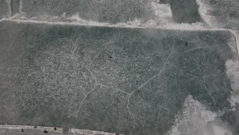 Aerial-Birds-Eye-View-Over-Ice-Hockey-Players-On-Frozen-Khalti-Lake-At-Ghizer-Valley