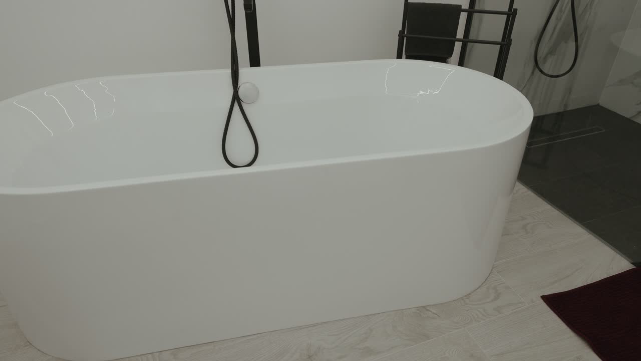 Bagno moderno con vasca da bagno bianca indipendente e tubo doccia nero