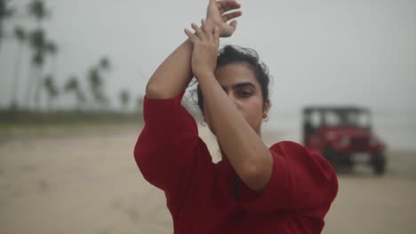 Girl-with-red-dress-meditation-in-beach-with-red-jeep-driving-by