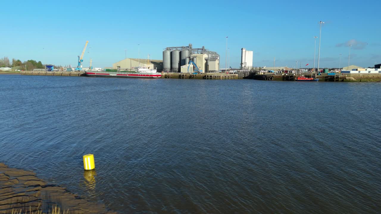 Vista aérea de una concurrida terminal portuaria en Kings Lynn mostrando grúas de muelle y grandes silos de almacenamiento.