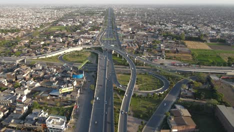 4k:-Drone-Sobrevolando-La-Pequeña-Ciudad-De-Punjab-En-Pakistán,-Vista-Del-Paso-Elevado-Del-Tráfico-Y-El-Tráfico-Urbano