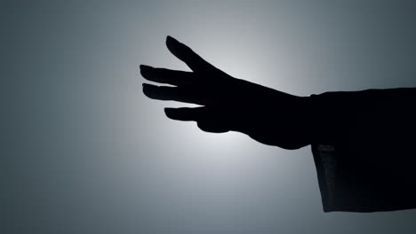 Girl-hand-silhouette-in-darkness.-Unrecognizable-woman-moving-arm-in-air.