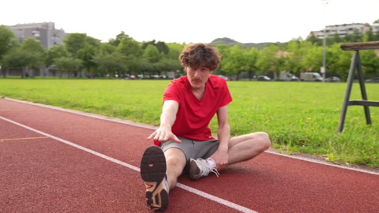 Athlete Stretching on a Track