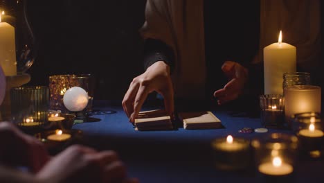 Close-Up-Of-Woman-Giving-Tarot-Card-Reading-To-Man-On-Candlelit-Table-2