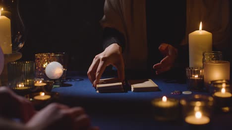 primer plano de una mujer dando una lectura de cartas de tarot a un hombre en la mesa 2 a la luz de las velas