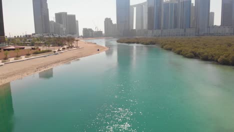 aerial flying forward over mangroves at al reem island on sunny day