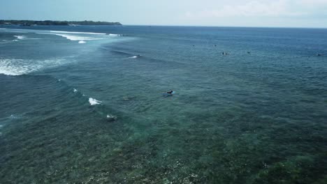 las paletas de surf sobre la ola a punto de romperse dirigiéndose de nuevo a la línea