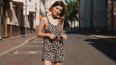 woman in a floral dress walking on a city street