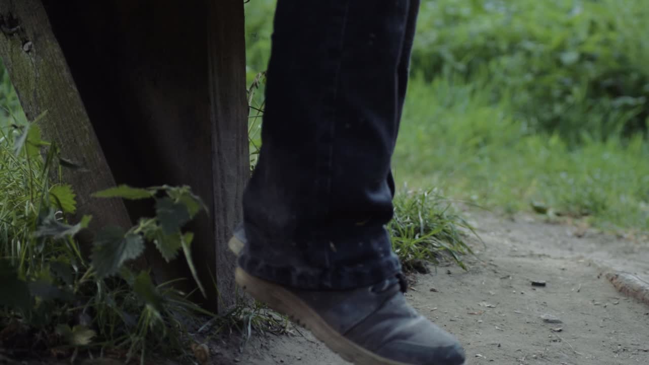 Primo piano di gambe che penzolano da una panchina in campagna