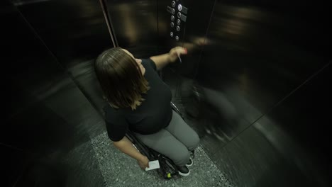 a woman in a wheelchair is inside an elevator, holding an item in her hands, as she waits for the elevator to reach her floor. the image highlights accessibility, independence, and modern infrastructure.