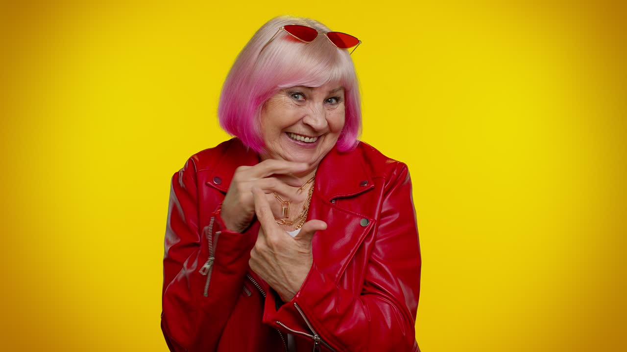 Anziana nonna che fa smorfie giocose e buffe, scherzando e mostrando la lingua.