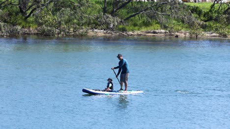 two people paddleboarding together on calm water