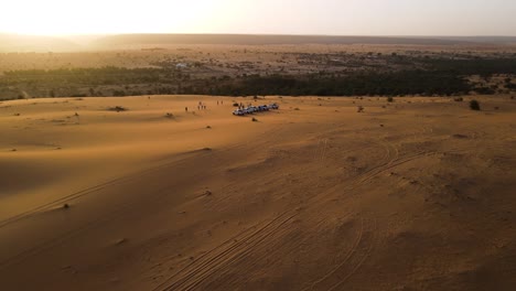 Coches-En-Dunas-De-Arena-Con-La-Hermosa-Puesta-De-Sol-Del-Desierto-Del-Sahara-En-El-Fondo,-Mauritania,-áfrica---órbita-Aérea