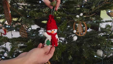 hanging colorful snowman decoration on green christmas tree close up 4k