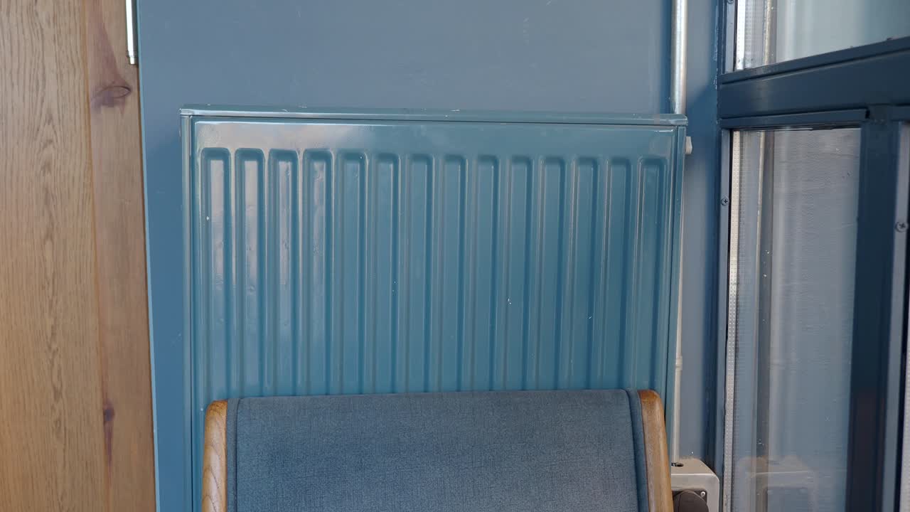 창문 에 있는 파란 라디에이터와 의자의 클로즈업