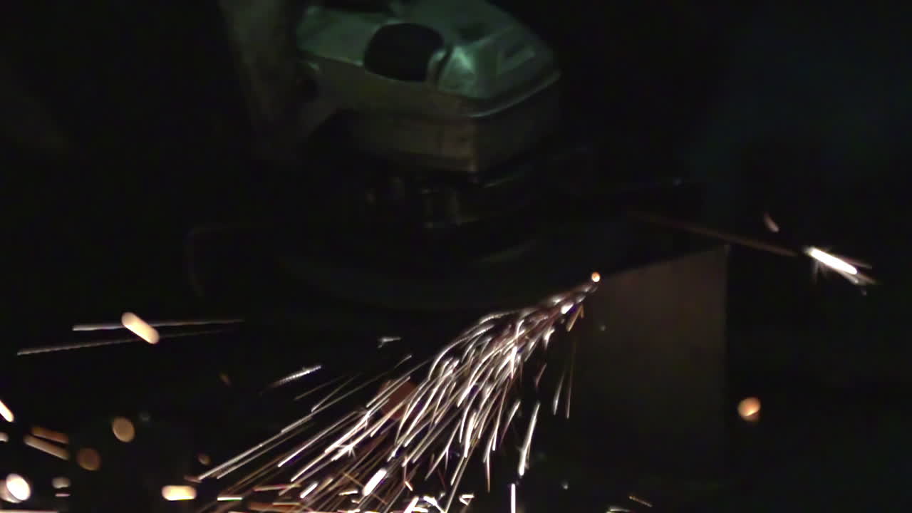 Angle Grinder Cutting Metal with Sparks Flying in Slow Motion in a Factory