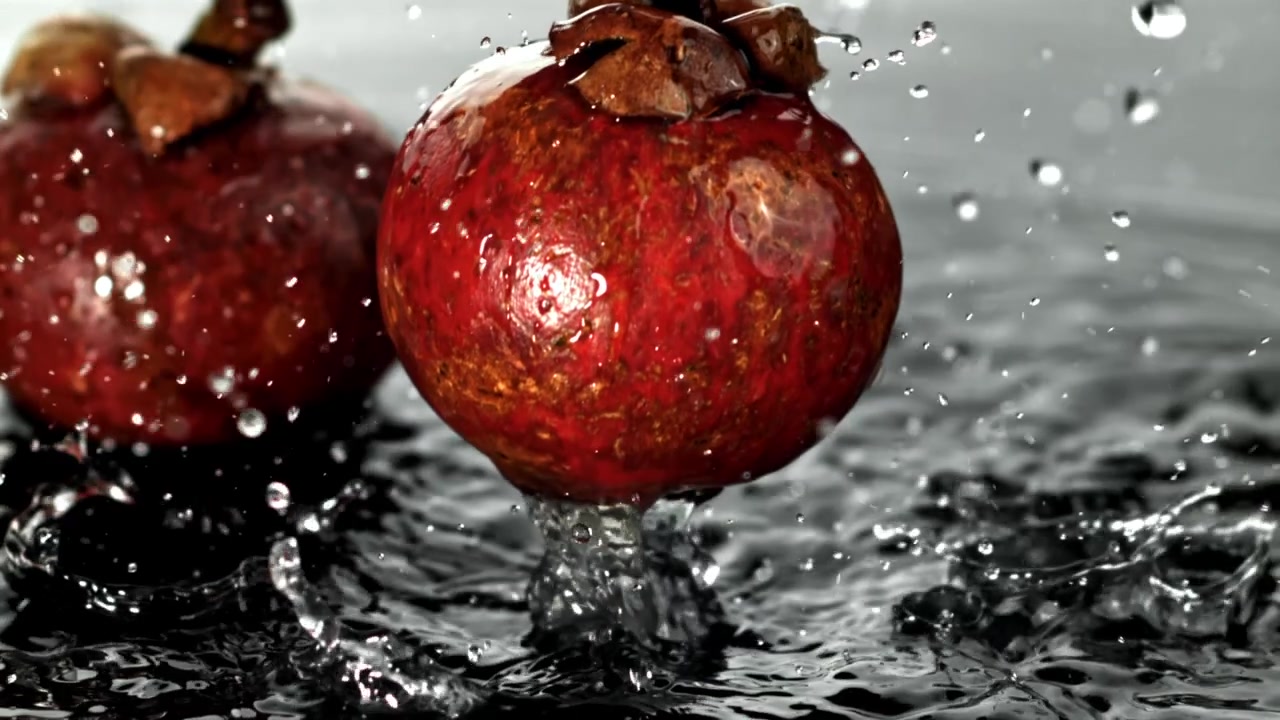 Mangostanfrugt falder ned i vand i slowmotion