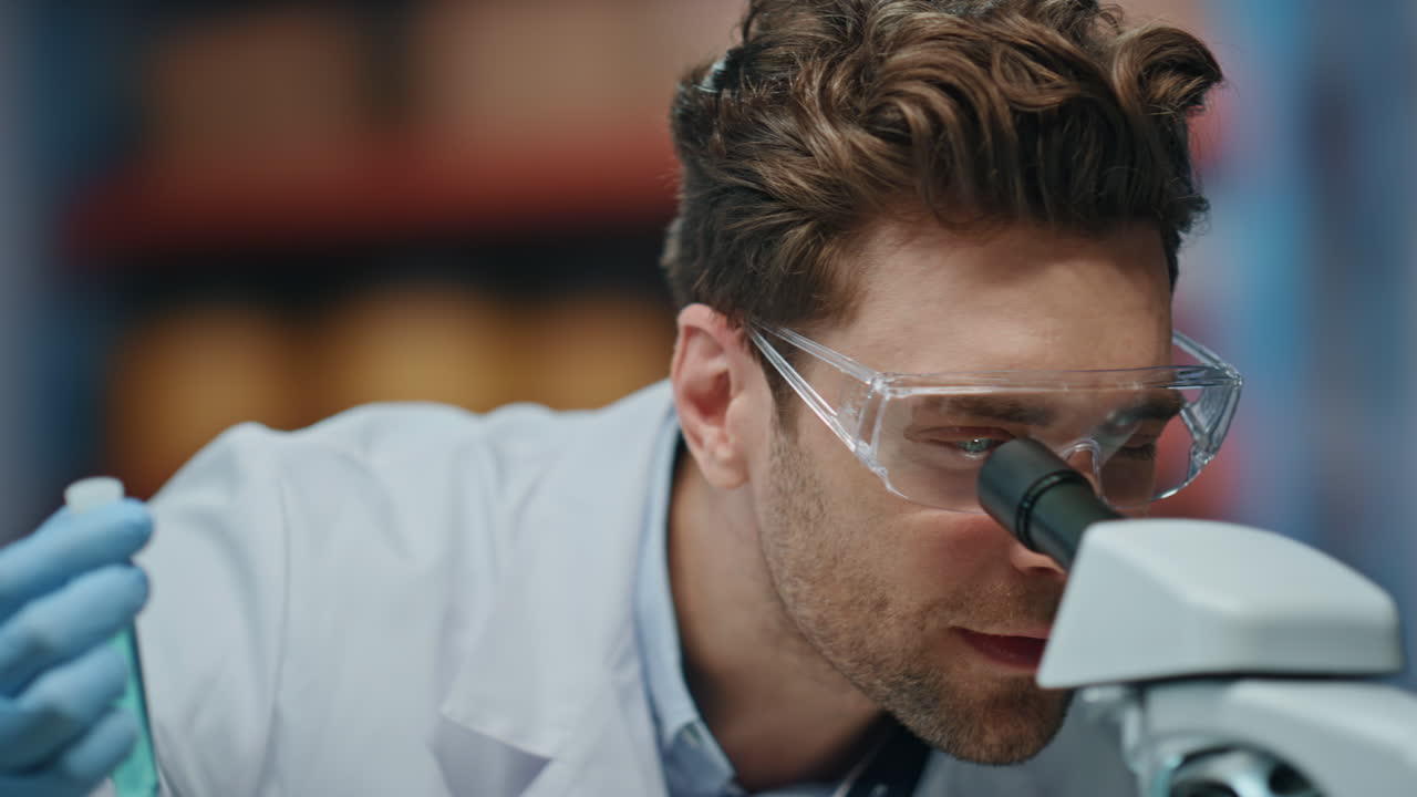 el retrato del científico satisfizo la investigación médica mirando el microscopio en el laboratorio.
