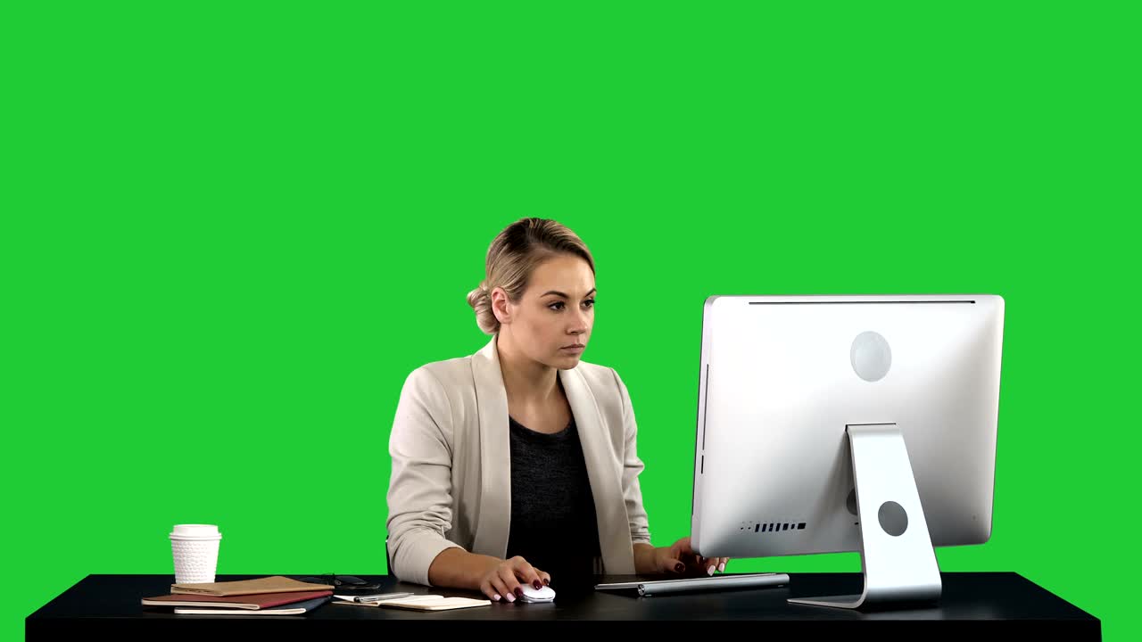 hermosa mujer rubia trabajando en la computadora en una pantalla verde, clave de croma