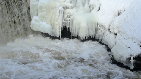 Zoom-En-Vista-De-Cascada-Cayendo-Sobre-Rocas-Cubiertas-De-Hielo-En-Cámara-Lenta