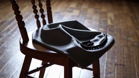 grey cloth draped over wooden chair with prayer beads