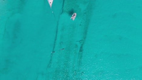 Luftaufnahme-Von-Oben-Nach-Unten-Mit-Drohnenansicht-Des-Kristallklaren-Wassers-Der-Bahamas-Mit-Schnorchlern-Und-Beibooten