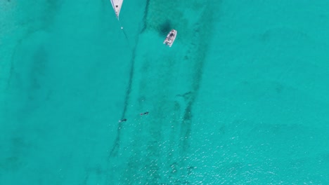 aerial top down drone view of bahamas crystal water with snorkelers and dingy