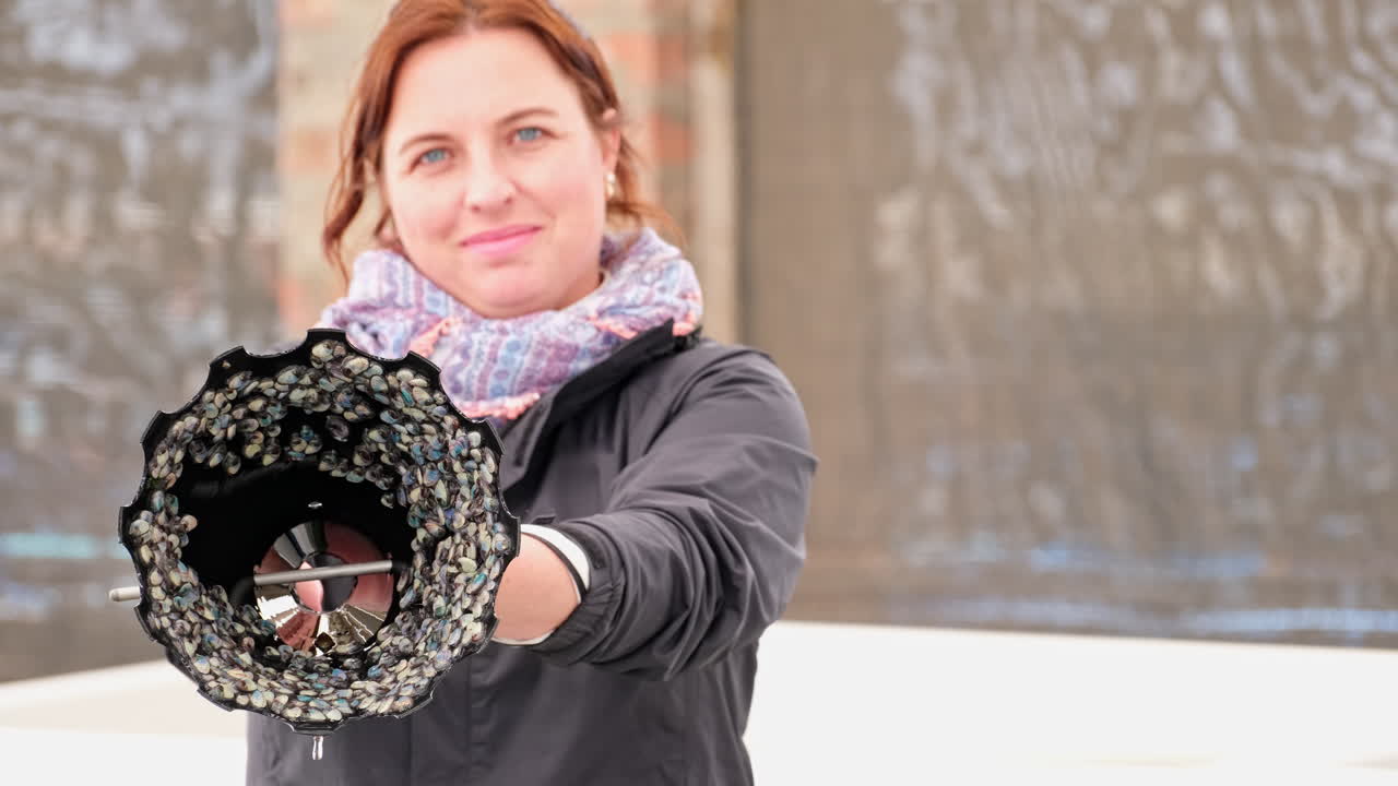 Woman proudly displaying her unique shell-based artwork
