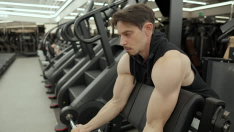 Bodybuilder-trainer-doing-Scott-barbell-bicep-curl-in-slow-motion-at-fitness-center---medium-shot,-slow-motion