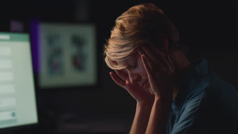 Tired-Businesswoman-Working-Late-In-Office-With-Face-Lit-By-Computer-Screen