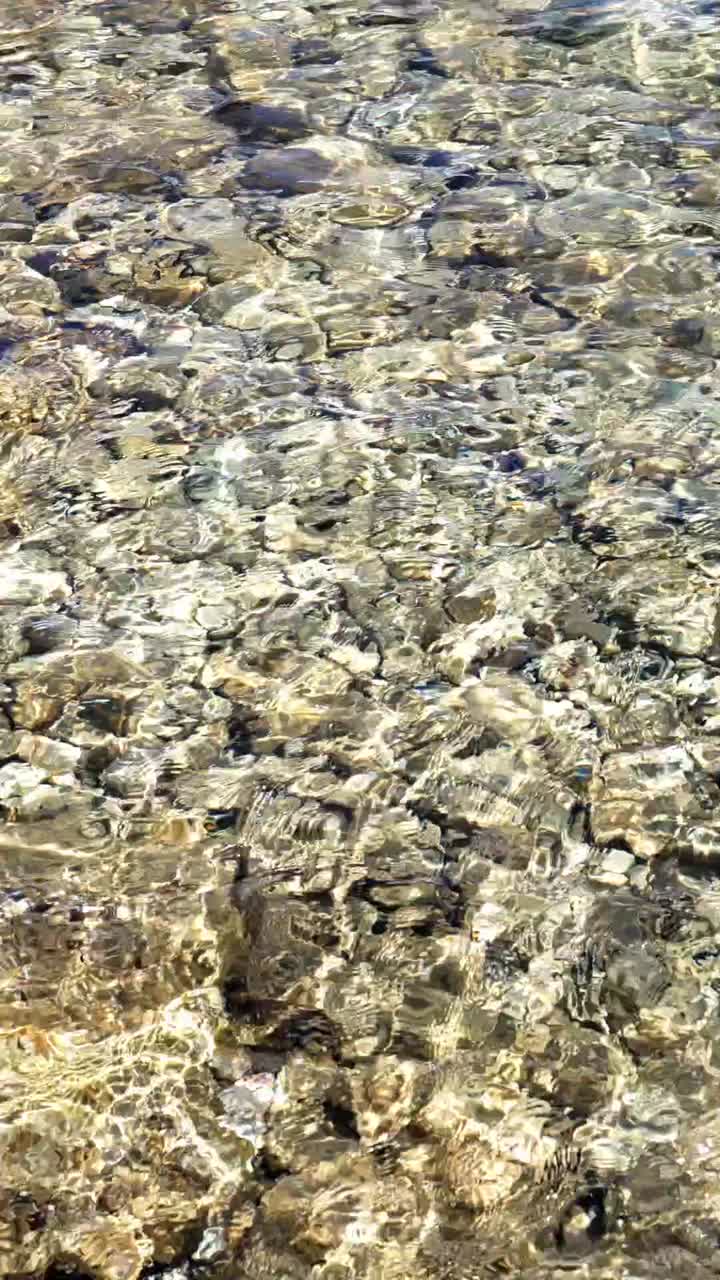 Sunlight Reflections on Clear Shallow Water Over Rocks