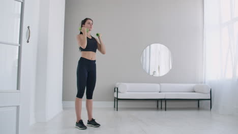 ejercicio básico para el músculo deltoide: una joven caucásica levanta pesas para ejercicios de brazo y hombro. levanta las pesas por encima de la cabeza