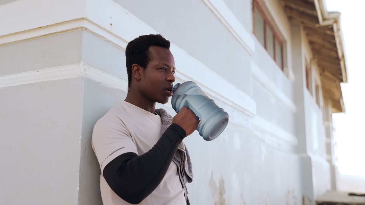 hombre negro, fitness y agua potable en la playa