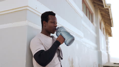 black man, fitness and drinking water on beach