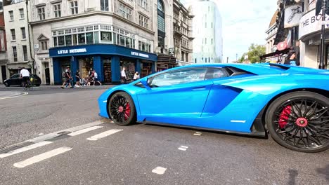 a blue supercar drives through a crowded intersection