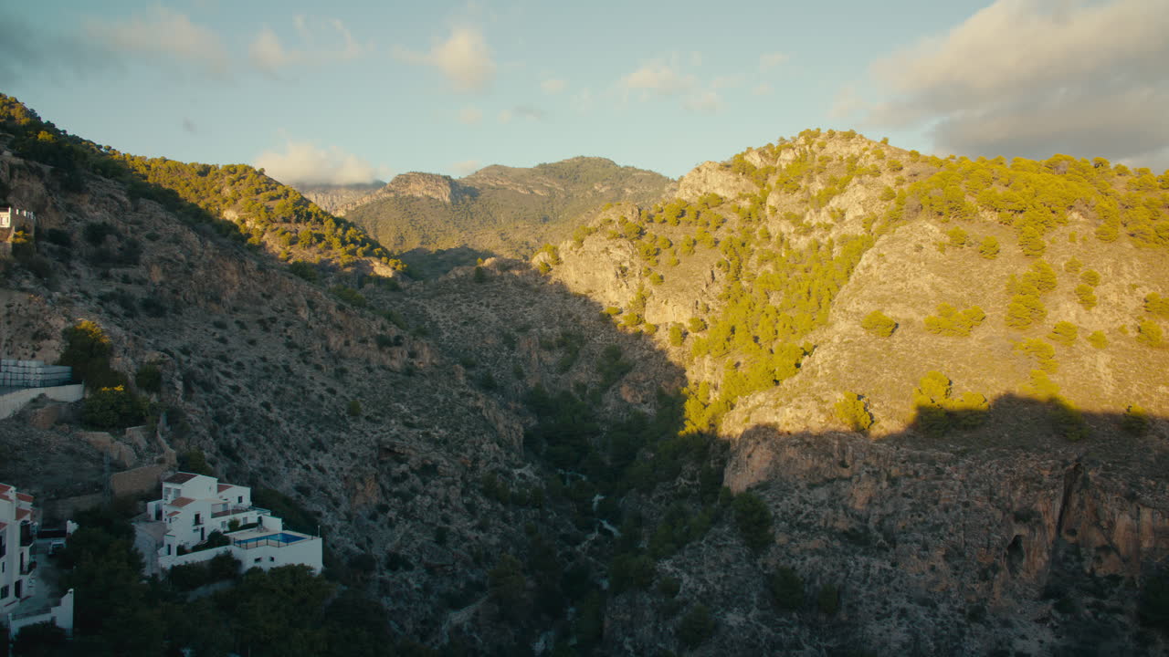 Dramatic mountain gorge bathed in evening light at the edge of Sierra Nevada, seen from a white village in Andalusia