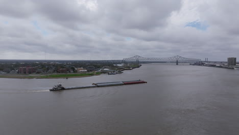 Imágenes-Aéreas-Que-Giran-Alrededor-De-Una-Barcaza-Que-Navega-Por-El-Río-Mississippi-Y-Revelan-El-Centro-De-Nueva-Orleans.