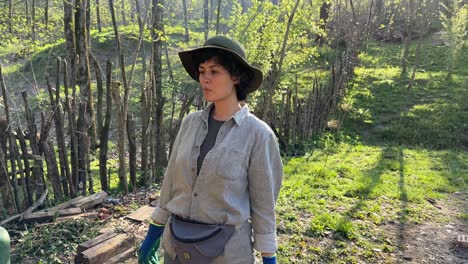 una trabajadora está bebiendo agua para hidratar el cuerpo después de trabajar duro en el fuego madera para quemar palo de madera para hacer fuego para hornear pan en barro horno de tubo caliente en una aldea forestal en la tarde del atardecer en irán