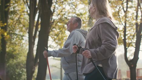 caucasian senior couple nordic walking in the park