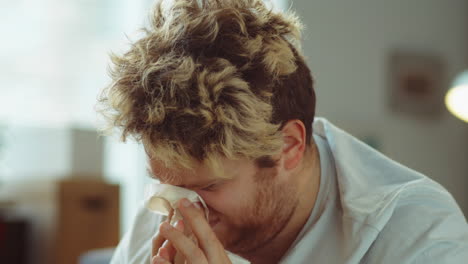 sick man sneezing and using nasal spray