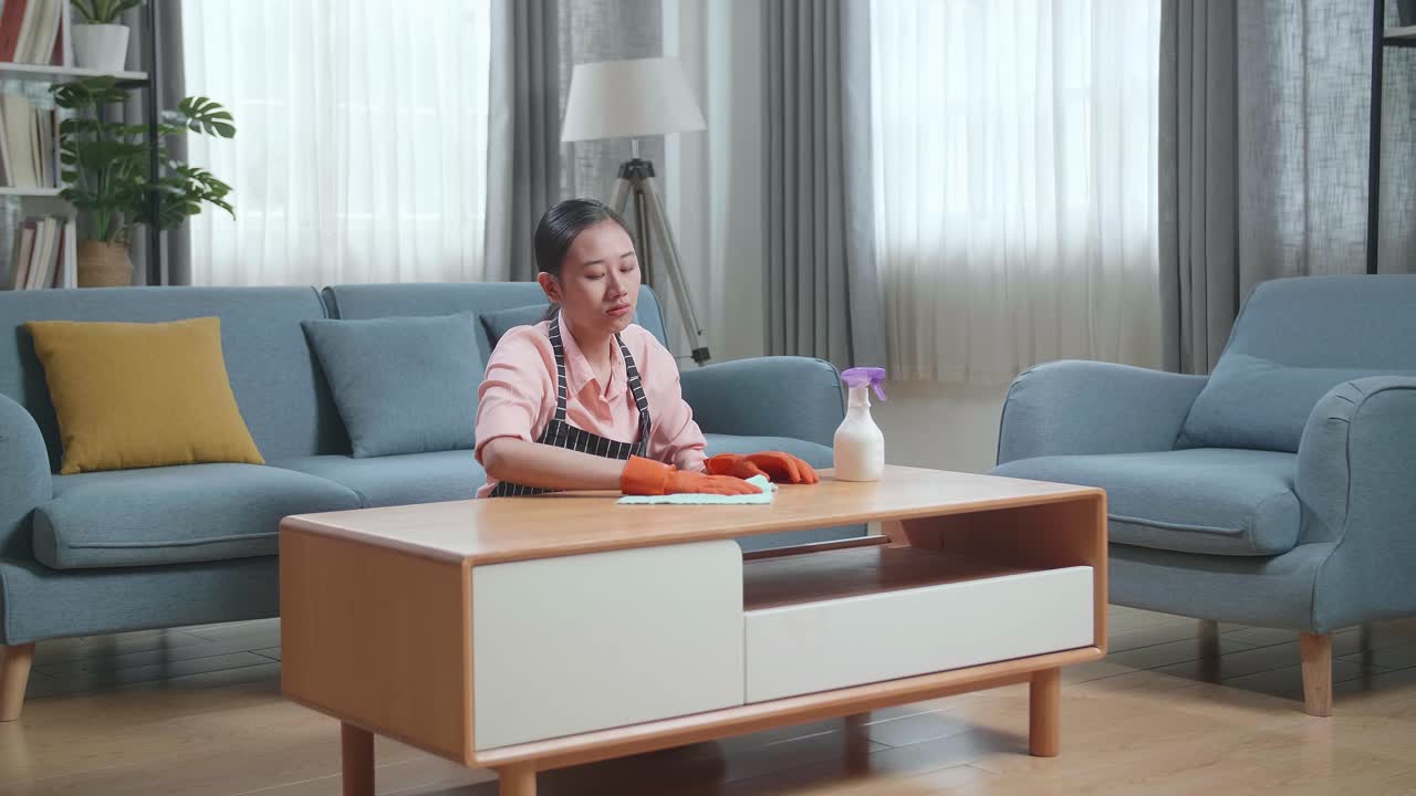 Tired Housekeeper Cleaning the Coffee Table