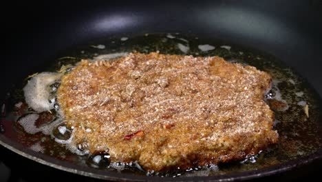 cortar chuletas de carne en migas de pan con corteza crujiente frita en aceite vegetal en la sartén.