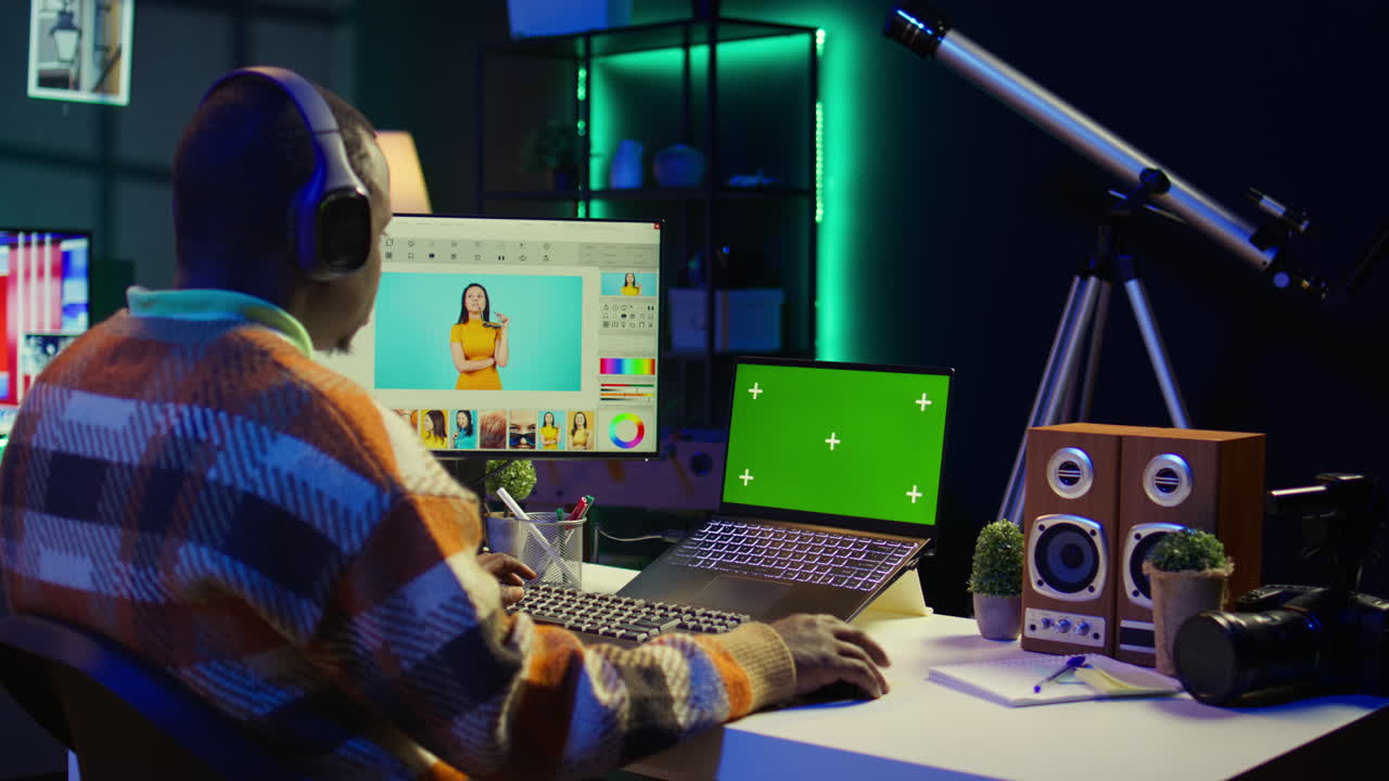 Man editing video with green screen on computer